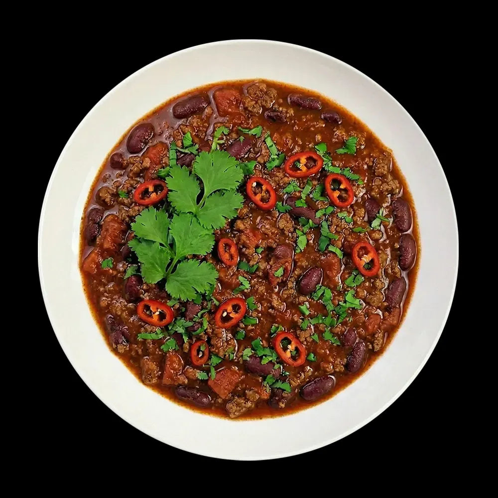 Herzhaftes Chili con Carne, frisch angerichtet in einer weißen Schale. Man erkennt feines Hackfleisch, rote Kidneybohnen und Tomatenstückchen, verfeinert mit frischen Chiliringen und Koriander – perfekt für Liebhaber pikanter Metzgerqualität.