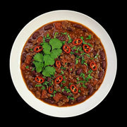 Herzhaftes Chili con Carne, frisch angerichtet in einer weißen Schale. Man erkennt feines Hackfleisch, rote Kidneybohnen und Tomatenstückchen, verfeinert mit frischen Chiliringen und Koriander – perfekt für Liebhaber pikanter Metzgerqualität.